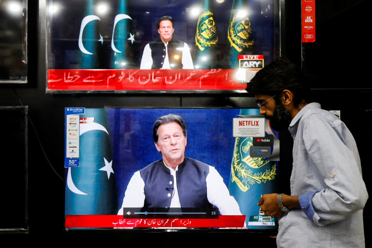 A shopkeeper tunes a television screen to watch the speech of Pakistani Prime Minister Imran Khan, at his shop in Islamabad, Pakistan, on March 31, 2022.