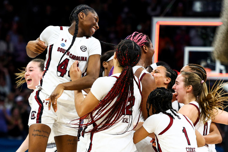 The South Carolina Gamecocks celebrate with teammates after defeating the UConn Huskies 64-49 during the 2022 NCAA Women's Basketball Tournament National Championship game on April 3, 2022, in Minneapolis.