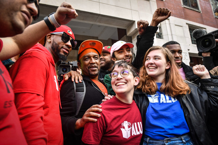 Image: Union organizer Christian Smalls, left, celebrates following the April 1, 2022, vote for the unionization of the Amazon Staten Island warehouse in New York.