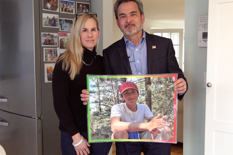 Mike and Kristin Song with a picture of their son, Ethan Song, 15. Ethan died after he accidentally shot himself with a neighbor's handgun that was stored in a closet shoebox.