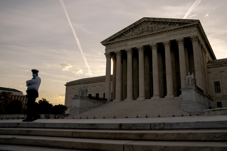 A police officer stands in front of the U.S. Supreme Court.