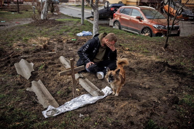 Image: Serhii Lahovskyi mourns next to the grave of his friend Ihor Lytvynenko, in Bucha