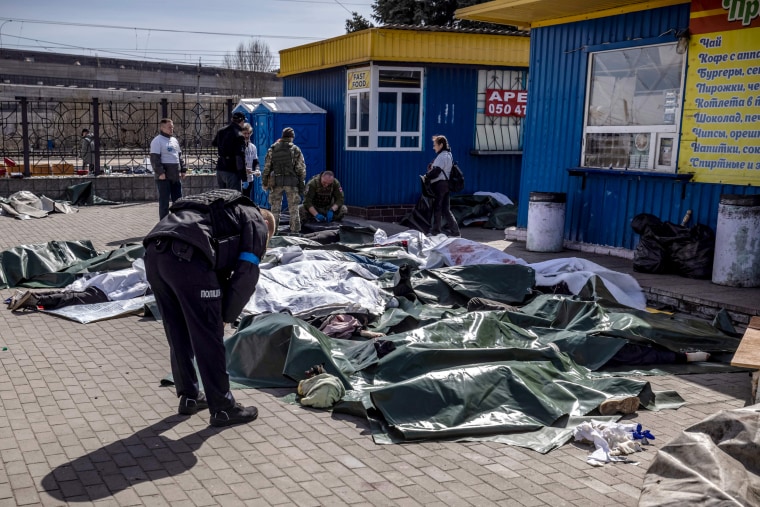 Image: A Ukrainian policeman looks at victims of a rocket attack that killed at least 35 people at a train station in Kramatorsk on April 8, 2022.