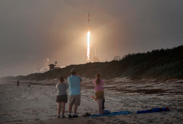 Image: Spectators watch a SpaceX Falcon 9 rocket carrying Starlink satellites launch from the Kennedy Space Center in Florida in 2020.