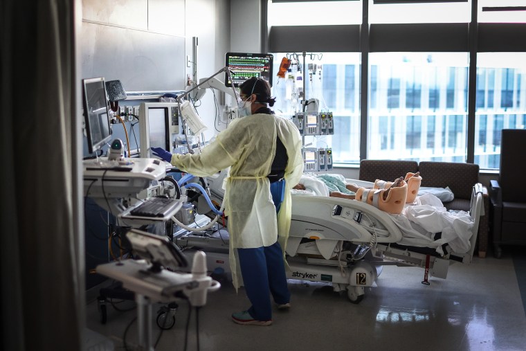 A respiratory therapist works with a Covid-19 patient in the ICU at Rush University Medial Center on Jan. 31, 2022 in Chicago.
