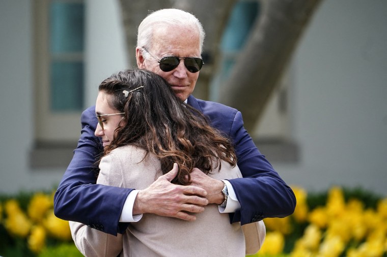 Image: President Joe Biden hugs Mia Tretta, a Saugus High School shooting survivor, during an event on measures to combat gun crime in the Rose Garden of the White House on April 11, 2022.