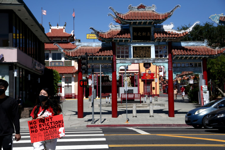 Image: People hold up signs as protesters supporting a rent freeze gather in Chinatown on Aug. 10, 2020 in Los Angeles.