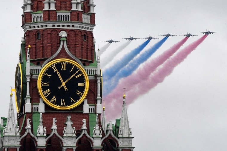 Image: Sukhoi Su-25 assault aircrafts release smoke in the colours of the Russian flag while flying over central Moscow during the Victory Day military parade on May 9, 2021