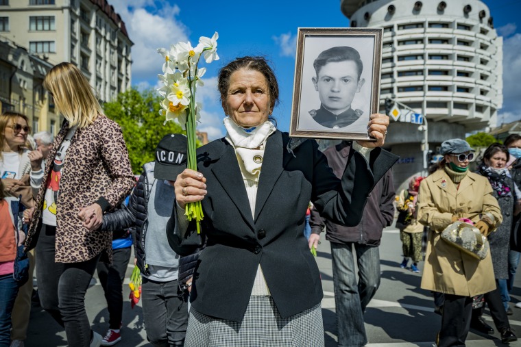 A woman holds a portrait of a relative who fought in World War II on Victory Day on May 9, 2021, in Kyiv, Ukraine.