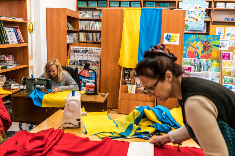 Viktoria Mashtalir, left, and Viktoria Havrilenko sew flags of Ukraine and the Ukrainian Insurgent Army at the Roman Ivanychuk Regional Youth Library on April 12, 2022, in Lviv, Ukraine.