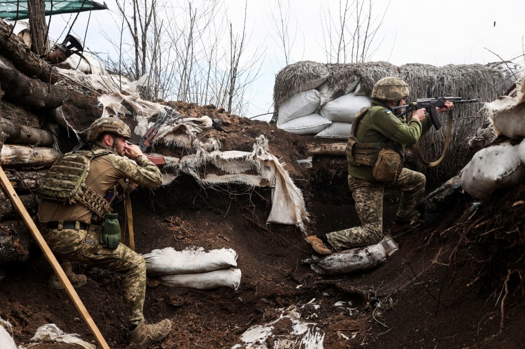 Ukrainian soldiers shoot from a trench on the front line with Russian troops in Lugansk region on April 11, 2022.