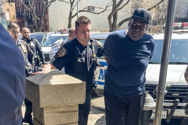 Police escort Frank R James, who is wanted in connection with Tuesday's subway mass shooting in Brooklyn, NY