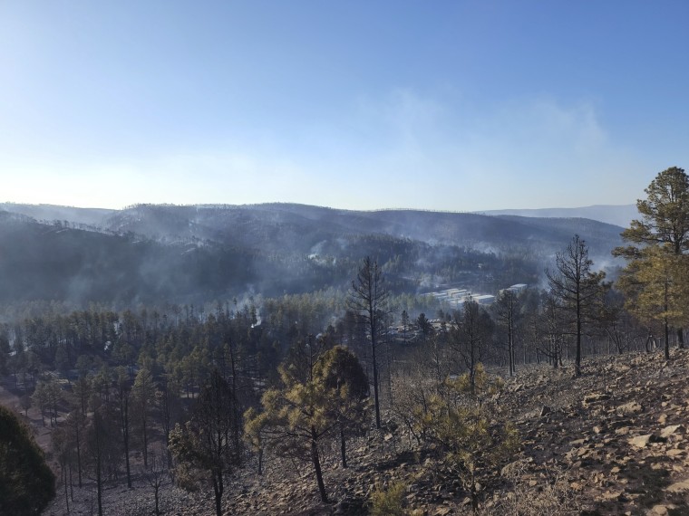 Smoke rises Wednesday along a hillside in the village of Ruidoso, New Mexico, where officials say a wildfire has burned about 150 structures, including homes.