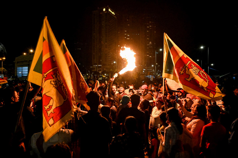 A protestor holds a torch during a demonstration against the economic crisis at the entrance of the president's office in Colombo, Sri Lanka, on April 13, 2022.