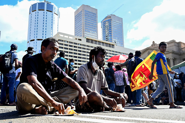 Protesters gather at the entrance of Sri Lankan President Gotabaya Rajapaksa's office while eating and sitting along a road in Colombo on April 14, 2022.