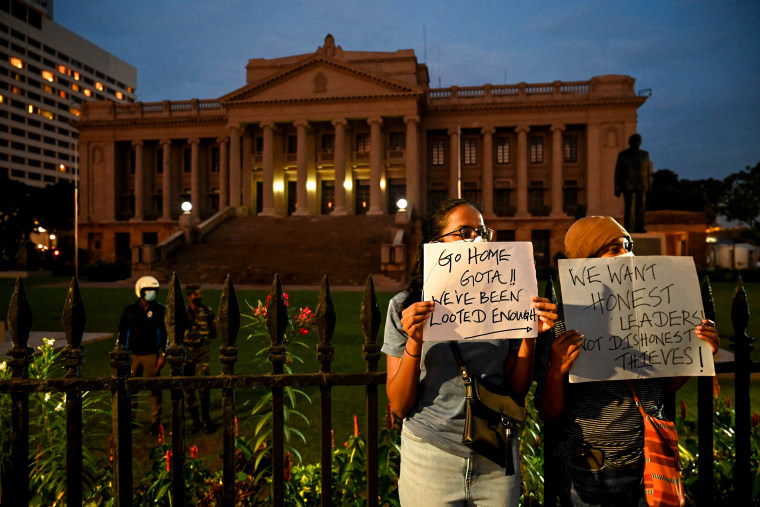 Protesters hold banners as they take part in a demonstration against the economic crisis in front of the gates of the presidential office in Colombo, Sri Lanka, on April 10, 2022.