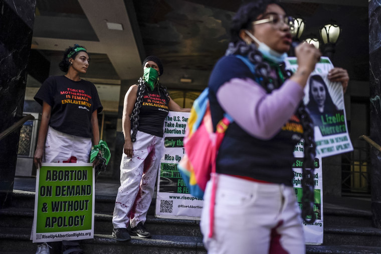 Image: Abortion rights advocates hold signs during a protest in support of Lizelle Herrera in Los Angeles on April 14, 2022.