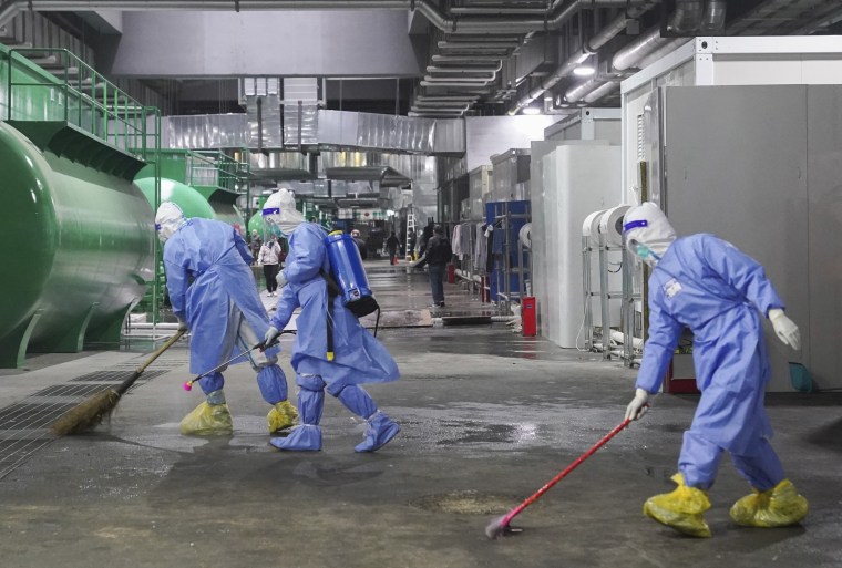 Workers disinfect the floor of a makeshift hospital at the National Exhibition and Convention Center in Shanghai on Thursday.