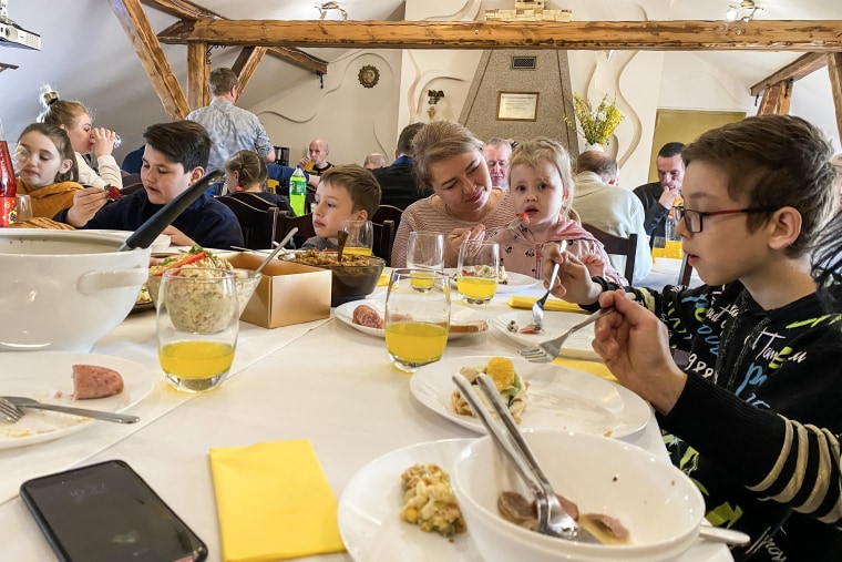Tetyana Gorshunova helps her daughter eat alongside other refugee families at an Easter breakfast in Warsaw.