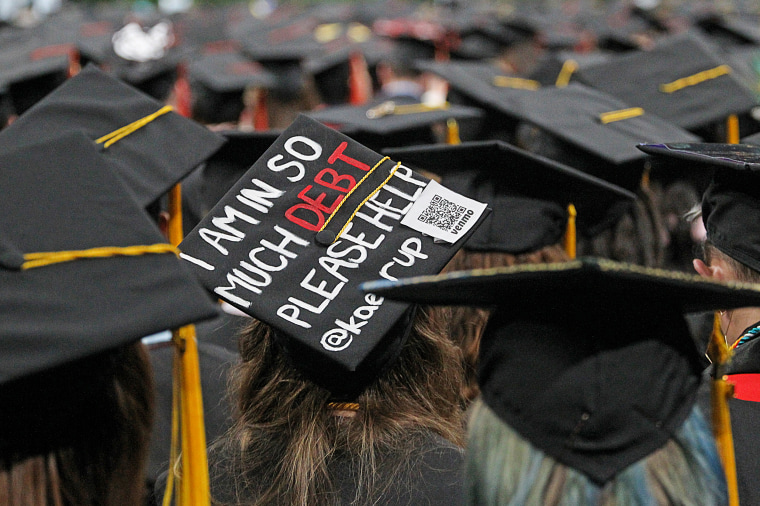 A note on a student's cap reads, "I am in so much debt please help" during graduation at Northeastern University on May 3, 2019.