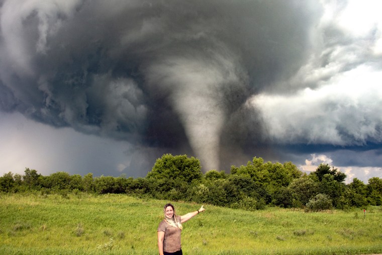 Melanie Metz poses with a tornado in the background in Ashby, Minn., on July 8, 2020.