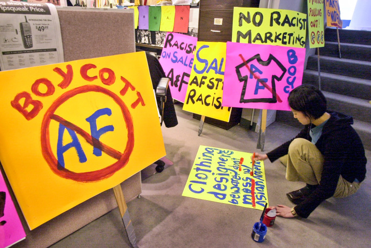 Pauli Wai of the Chinatown Community Developement Center works on posters before a demonstration in San Francisco on April 18, 2002, to protest about a line of five T-shirts depicting stereotypes that were sold by Abercrombie & Fitch.