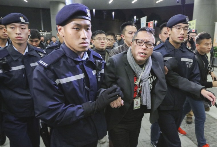 Activist Tam Tak-chi is escorted by police as police officers and security guards remove pan-democrats and activists who camped outside the Legislative Council in Tamar in protest of the proposed change to the rules at the Legislative Council meetings. 12