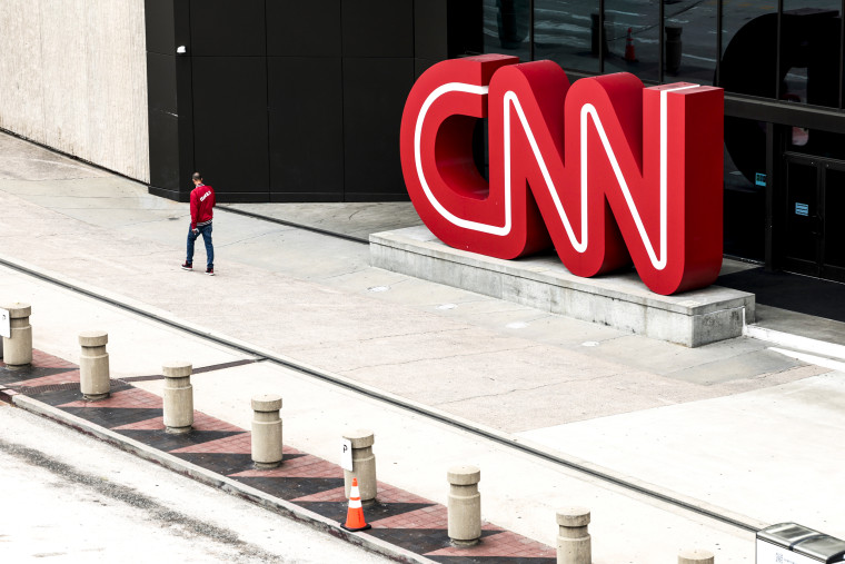 People walk by the world headquarters for CNN on March 15, 2022, in Atlanta.