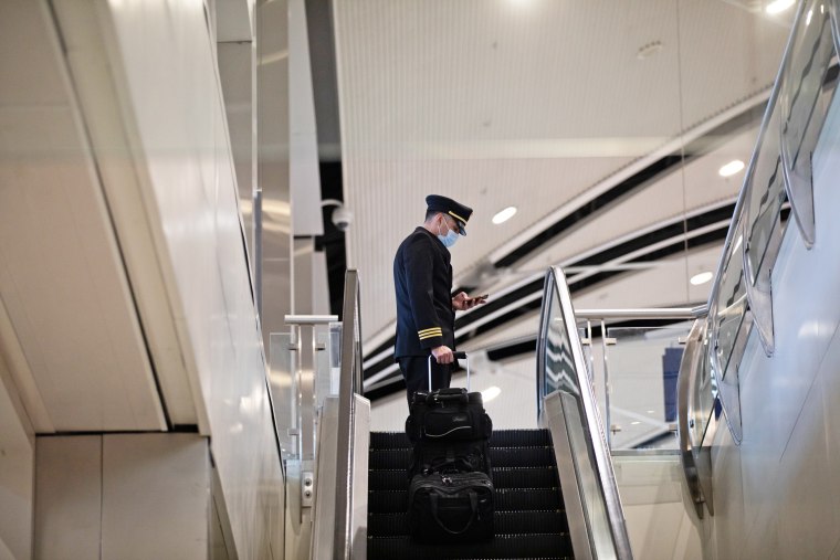 A pilot rides an escalator at the Detroit Metropolitan Wayne County Airport