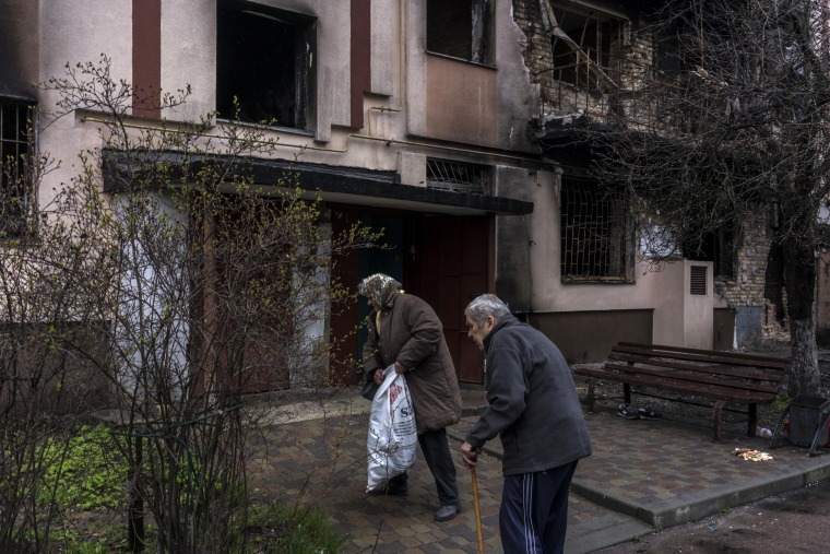 Image: Halyna Vasilenko and her husband, Mykola, remove items from their Bucha apartment that was struck by shelling during the Russian occupation.