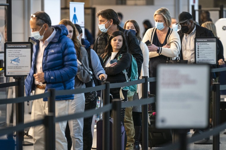 Image: Passengers wait in line at the security checkpoint at Ronald Reagan Washington National Airport, on April 19, 2022, in Arlington, Va.