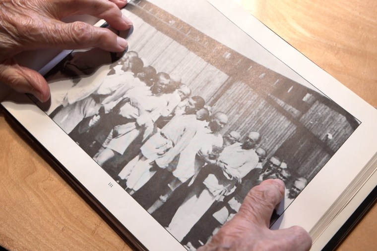 George Brent points to a picture of himself at Auschwitz.