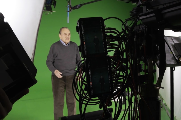 George Brent records a session with a green screen behind him.