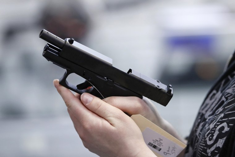 A person holds a Glock handgun