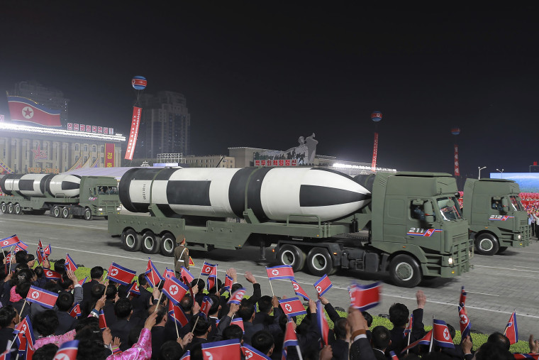 Military vehicles showcase ballistic missiles during the parade. 