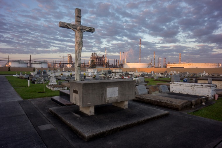 Image:  A cemetery stands in contrast to the chemical plants that surround it in "Cancer Alley" in Baton Rouge, La., on Oct. 15, 2013.