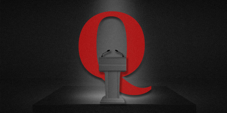 Photo Illustration: The QAnon logo behind a debate podium
