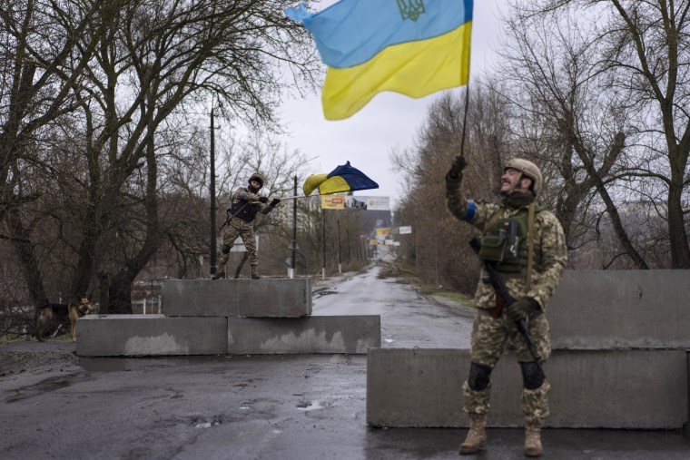 Un soldado ucraniano levanta una bandera de su país en Bucha, en las afueras de Kiev, el 3 de abril del 2022.