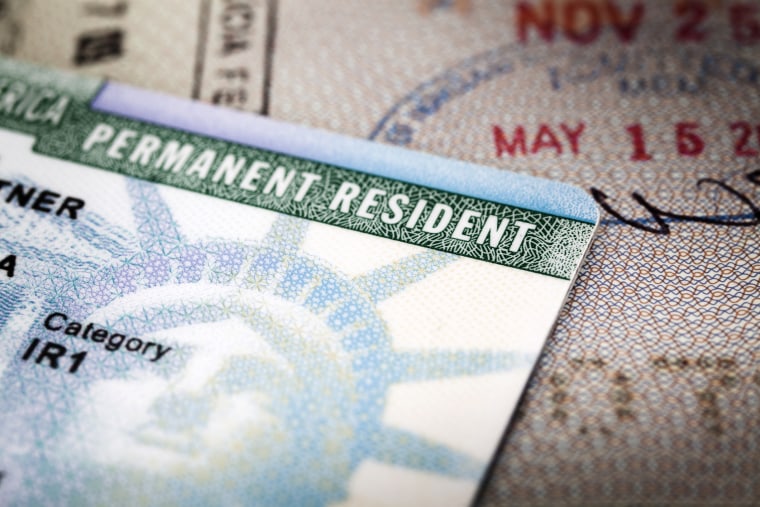 Una tarjeta de residencia permanente sobre un pasaporte.