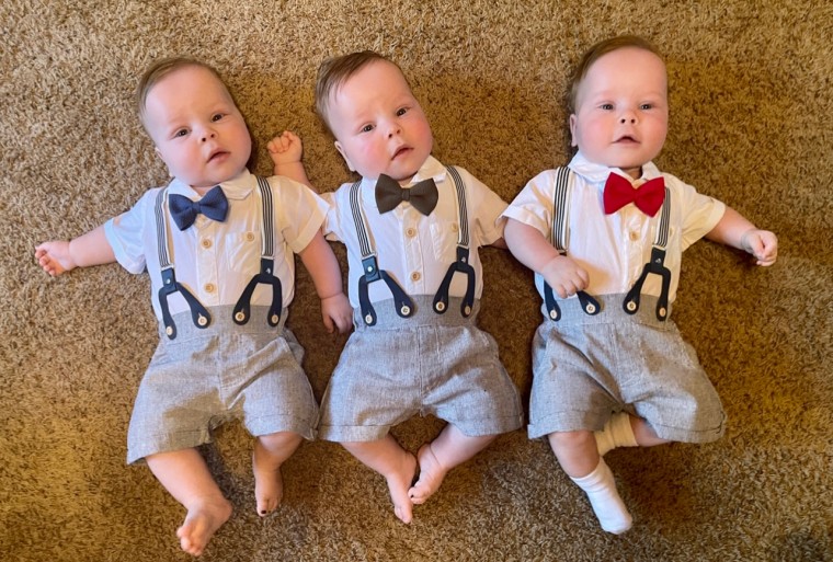 L-R: Henry, James and Thomas wearing their signature colors of blue, green and red. The color coding helps their parents tell the identical triplets apart.