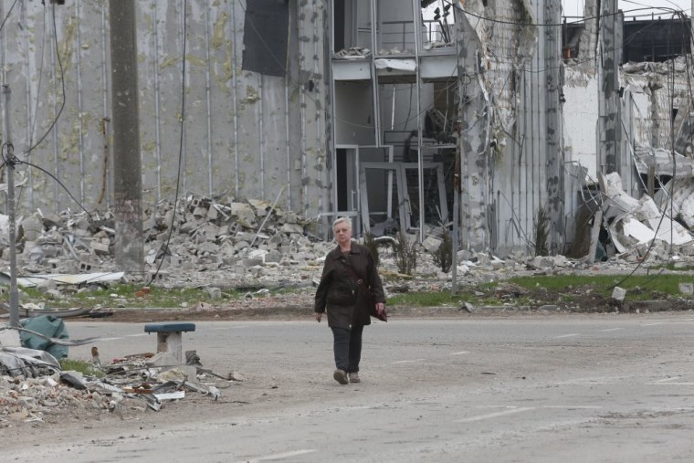 Un residente pasa por delante de los edificios dañados en Mariupol, el 19 de abril de 2022.