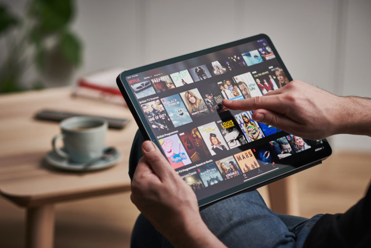 Un hombre utiliza Netflix en un Apple iPad Pro.