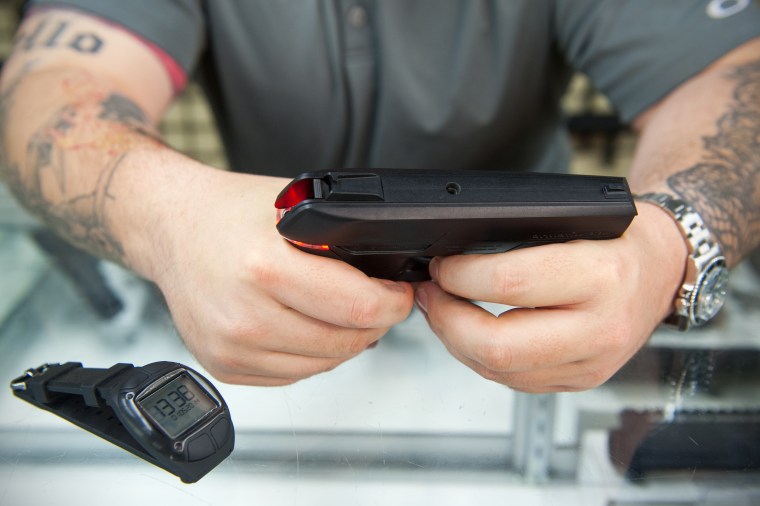 Andy Raymond hace una demostración de la Armatix iP1, una pistola inteligente de calibre 22 que tiene un sistema de seguridad que se sincroniza con el reloj, el 1 de mayo de 2014 en Rockville, Maryland.