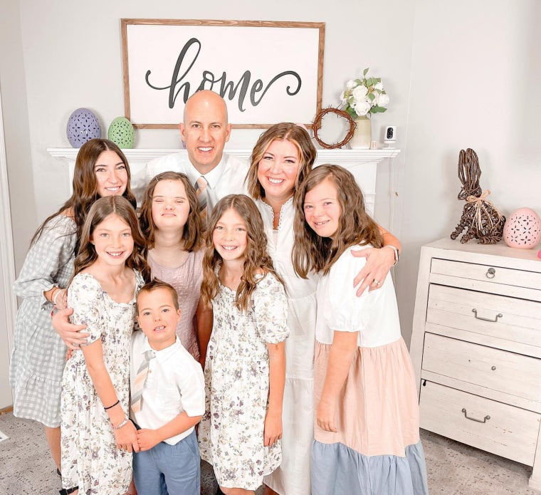 Noah, pictured front and center in a white shirt and tie, smiles for a photo with his family in Utah.