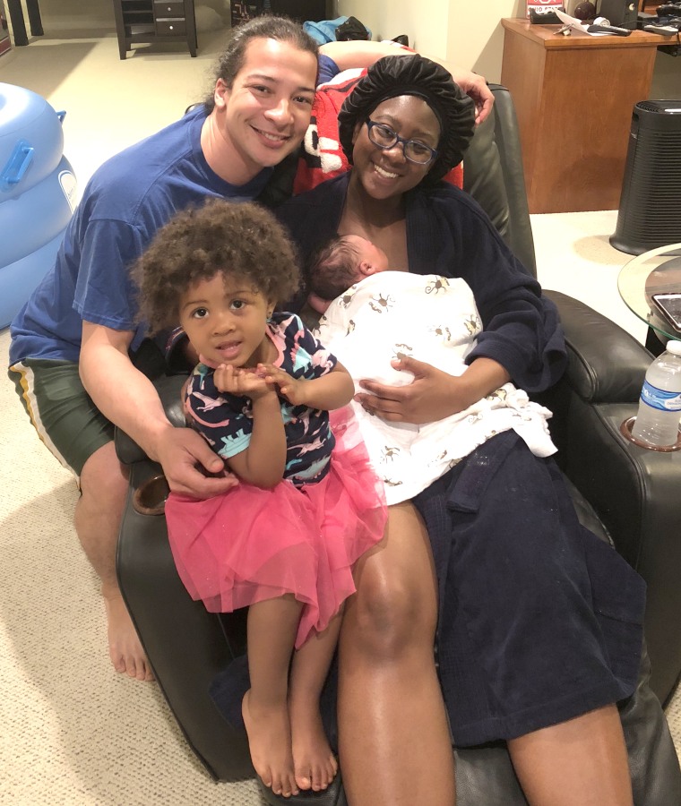 Gourrier's family surrounds her as he holds her newborn son, Omari, in 2018.