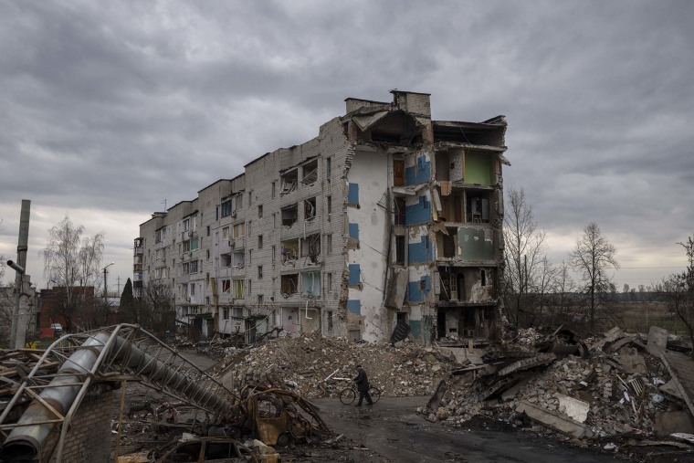 Un hombre camina con una bicicleta junto a un apartamento de apartamentos destruido en la localidad de Borodyanka, Ucrania, el sábado 9 de abril de 2022. Tropas rusas ocuparon la población durante semanas.