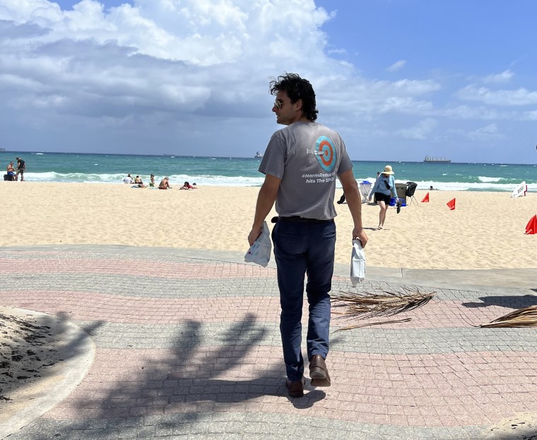Huston Ochoa, a clinical counselor for The Spot, hands out samples of Narcan, which can reduce opioid overdoses, to spring breakers on Fort Lauderdale Beach, Fla., on March 31, 2022.