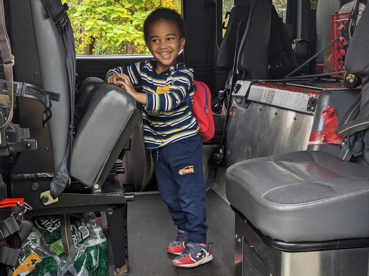 The author's son is all smiles aboard a fire truck.