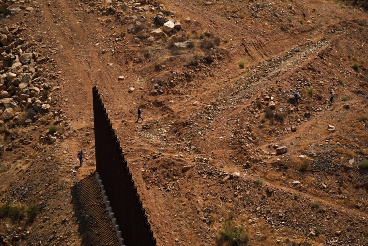 Dos personas cruzan a Estados Unidos desde Tijuana, México, en una zona donde se está construyendo el muro, el viernes 13 de agosto de 2021, en San Diego, California.