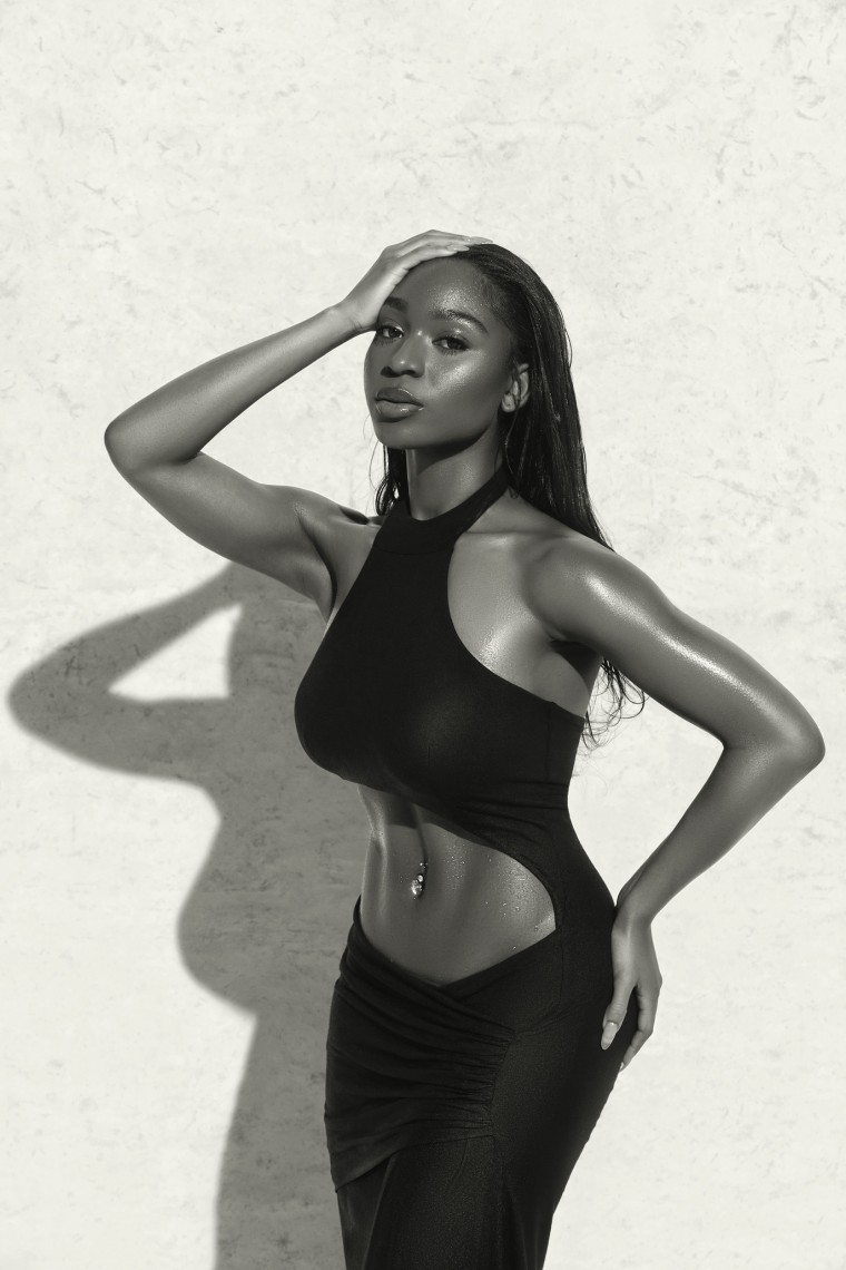 Normani poses for a black-and-white photo in a sexy gown that features her toned midsection.